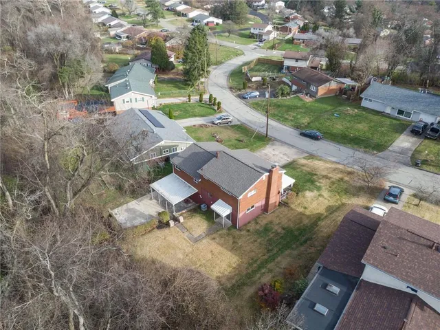 an aerial view of a house with garden space and street view