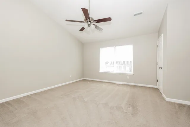 an empty room with a window and a ceiling fan