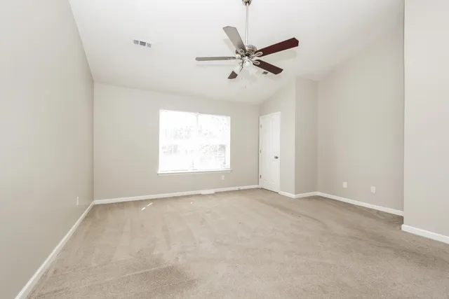an empty room with a window and a fan
