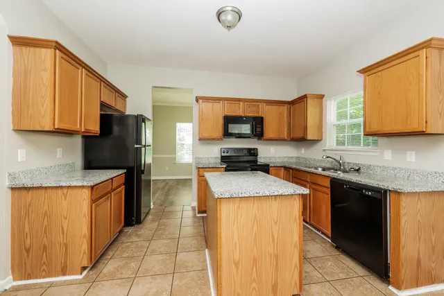 a kitchen with granite countertop a sink and a stove top oven