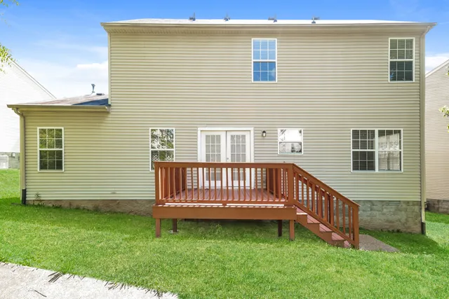 a view of a house with a backyard and deck