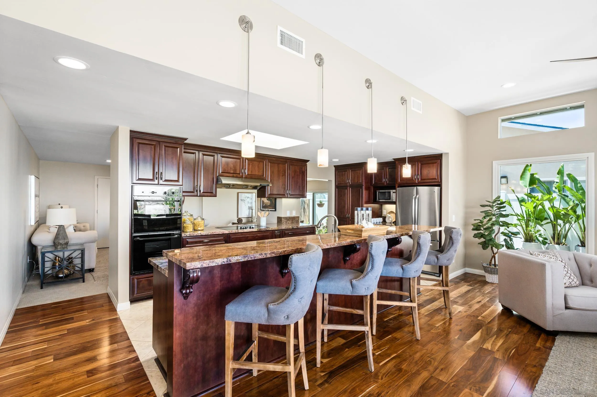 5785 Soledad Mountain Road La Jolla, CA 92037 - Photo 8 of 50 a dining room with stainless steel appliances kitchen island granite countertop a dining table chairs and view living room