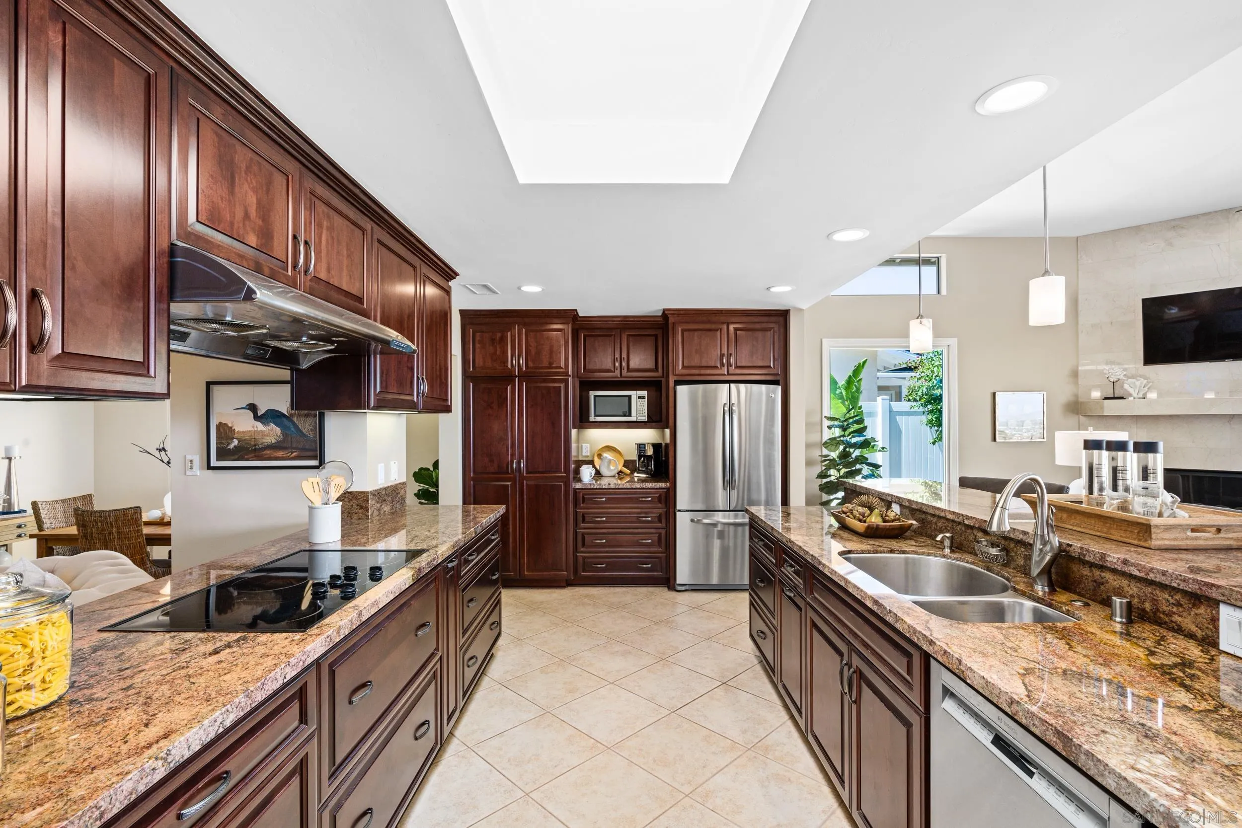 5785 Soledad Mountain Road La Jolla, CA 92037 - Photo 9 of 50 a large kitchen with stainless steel appliances granite countertop a large stove a sink dishwasher a oven and a dining table with wooden floor