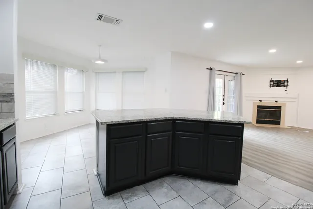 a kitchen with granite countertop a refrigerator and a sink