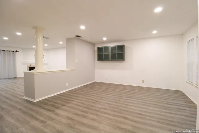 a view of empty room with wooden floor