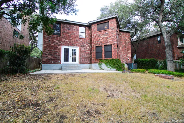 a front view of a house with yard and trees