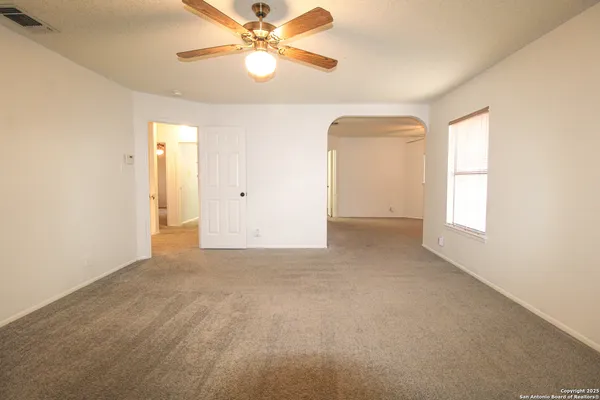 an empty room with a window and a fan