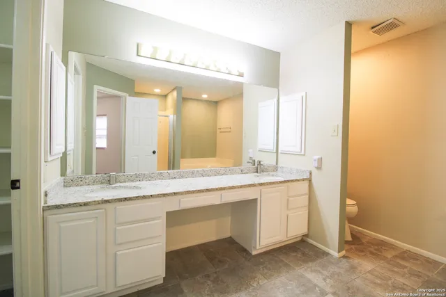 a bathroom with a granite countertop sink and a mirror