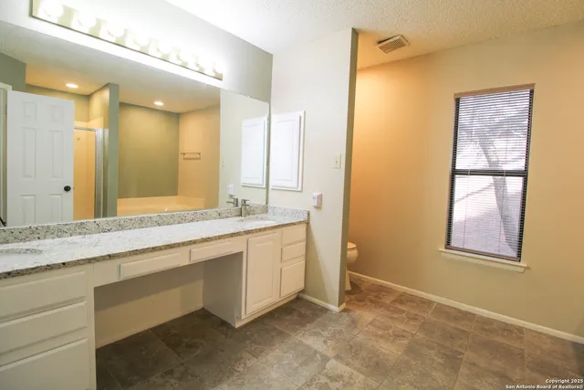 a bathroom with a granite countertop sink mirror and double
