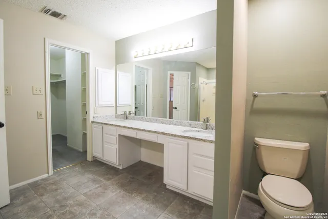 a bathroom with a toilet a sink a mirror and vanity