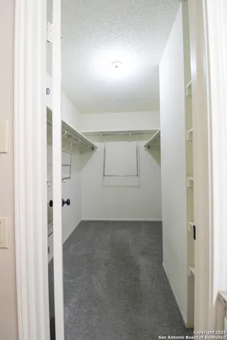 an empty room with windows and chandelier fan