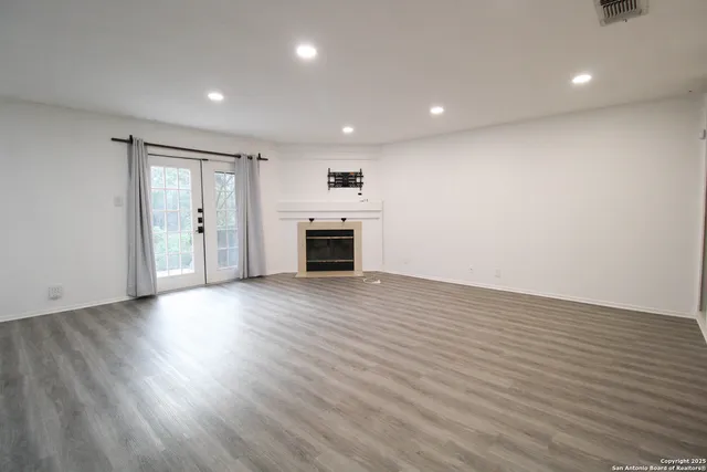 an empty room with wooden floor and a window