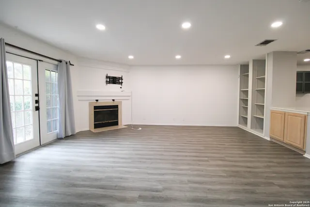 an empty room with wooden floor and fireplace