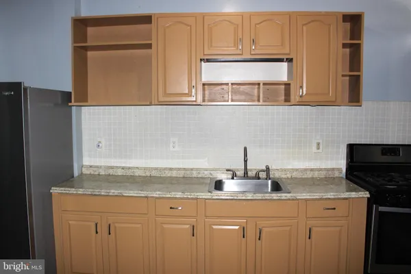 a kitchen with granite countertop stainless steel appliances white cabinets and a sink