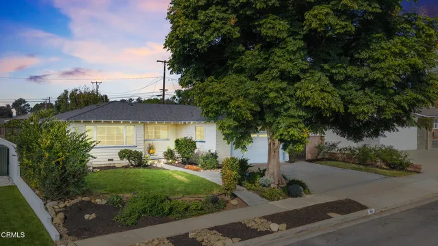 a view of a house with a yard and tree s