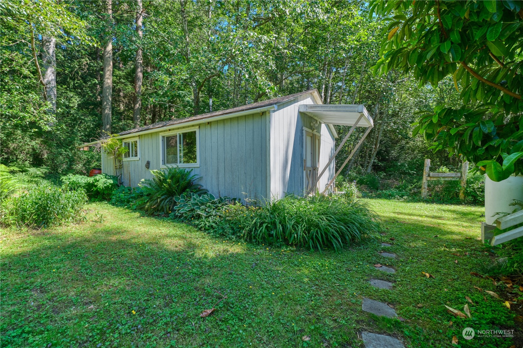 1721 Benson Road, Unit 119 Point Roberts, WA 98281 - Photo 18 of 24 a view of a backyard with plants and large trees