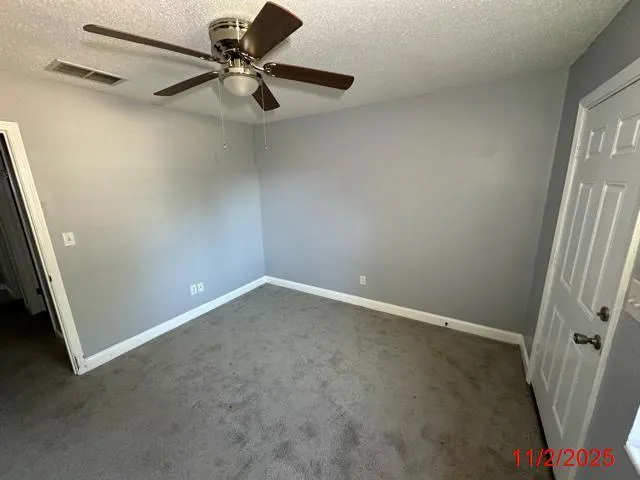 a view of a backyard with plants and wooden fence