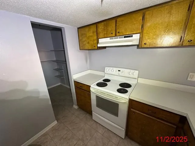 a view of an empty room with a kitchen