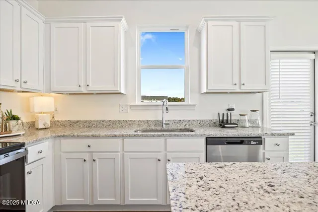 a kitchen with stainless steel appliances granite countertop a refrigerator stove and sink