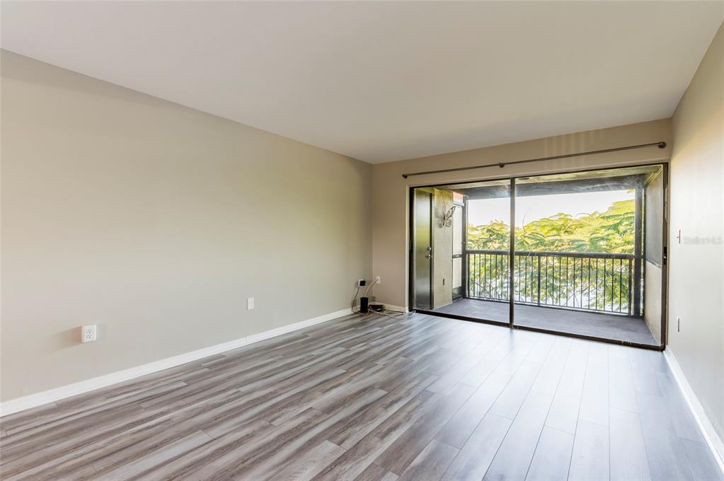 735 South Village Drive, Unit 206 St. Petersburg, FL 33716 - Photo 11 of 45 a view of an empty room with wooden floor and a window