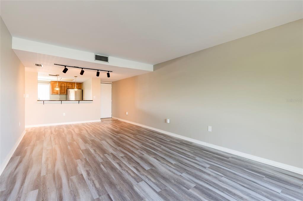 735 South Village Drive, Unit 206 St. Petersburg, FL 33716 - Photo 17 of 45 a view of a room with wooden floor and windows