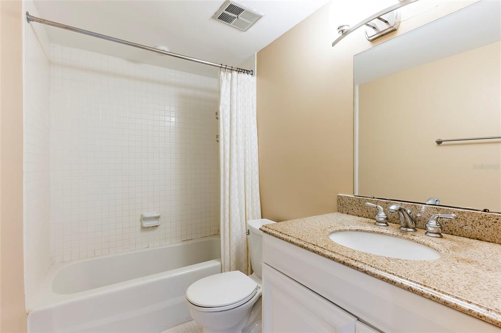 735 South Village Drive, Unit 206 St. Petersburg, FL 33716 - Photo 22 of 45 a bathroom with a granite countertop sink toilet and shower