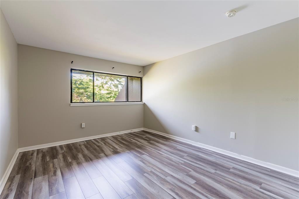 735 South Village Drive, Unit 206 St. Petersburg, FL 33716 - Photo 29 of 45 a view of room with window and wooden floor