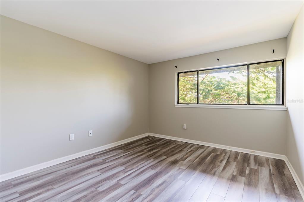 735 South Village Drive, Unit 206 St. Petersburg, FL 33716 - Photo 30 of 45 a view of room with window and wooden floor