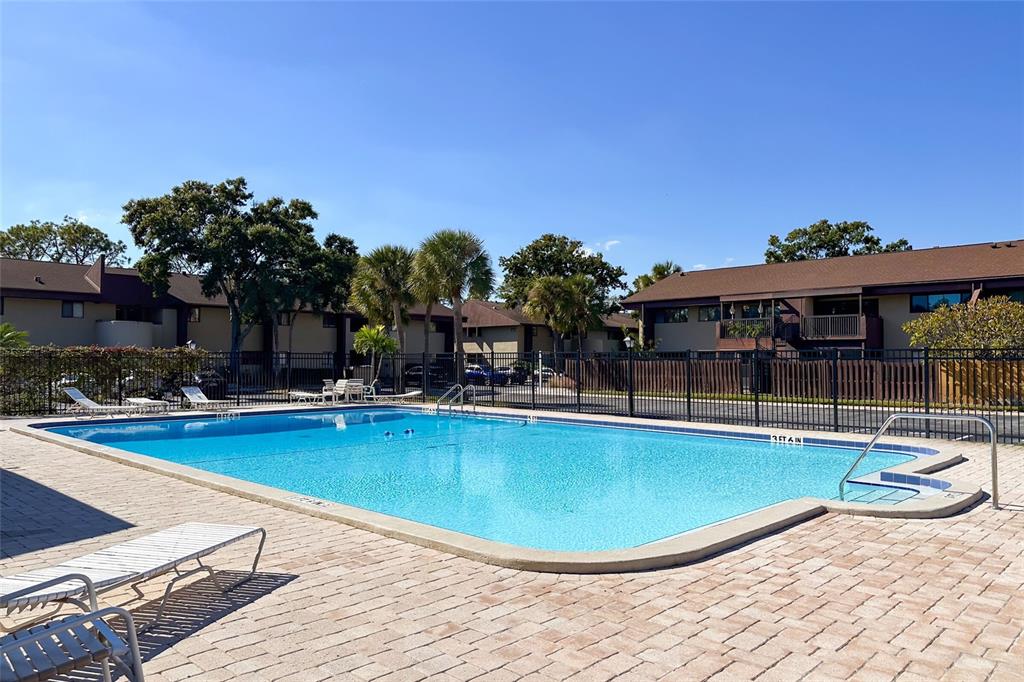 735 South Village Drive, Unit 206 St. Petersburg, FL 33716 - Photo 38 of 45 a view of a swimming pool with lounge chairs