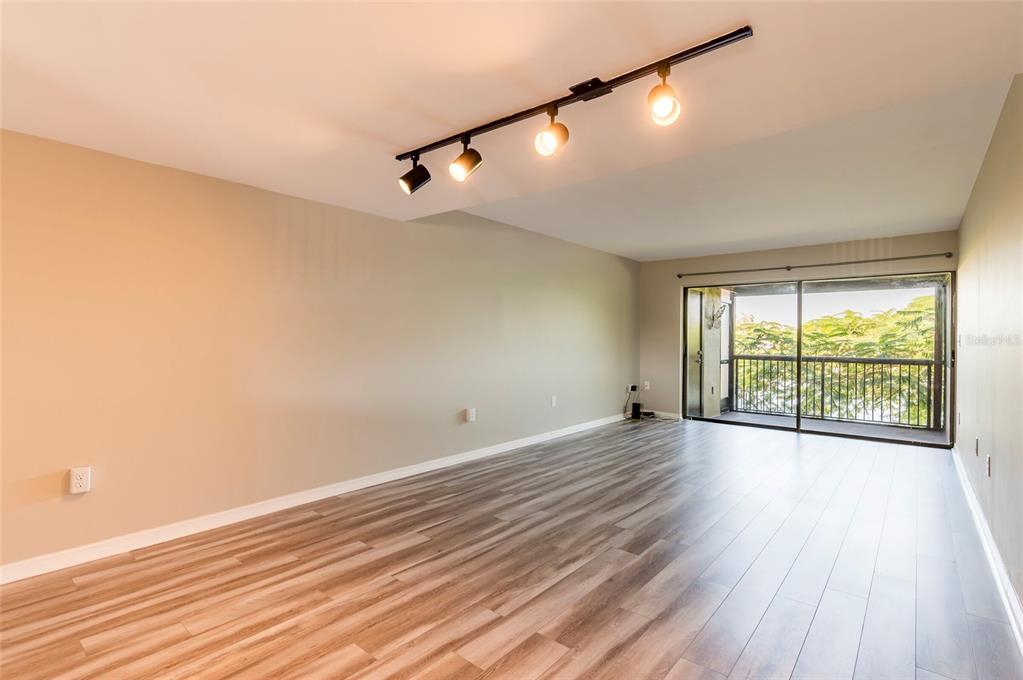 735 South Village Drive, Unit 206 St. Petersburg, FL 33716 - Photo 10 of 45 a view of an empty room with wooden floor and a window