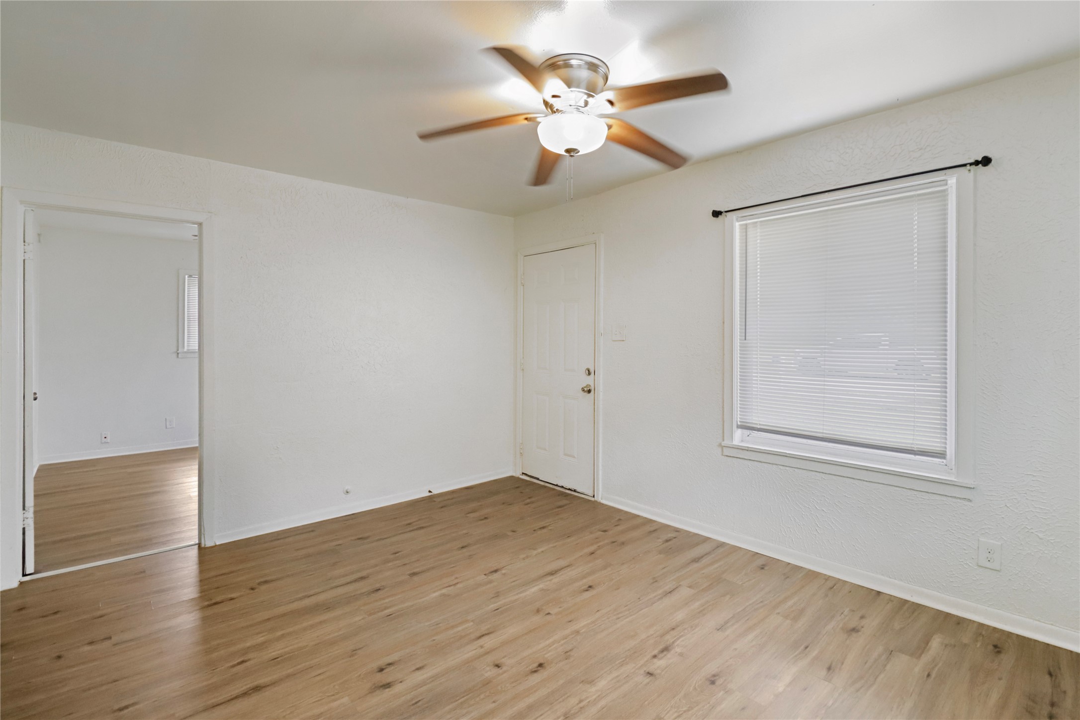 604 West Peach Street Angleton, TX 77515 - Photo 6 of 15 a view of an empty room with wooden floor and a window