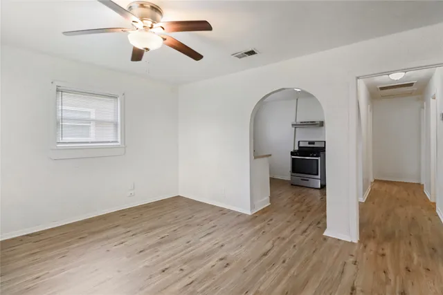 a view of empty room with wooden floor