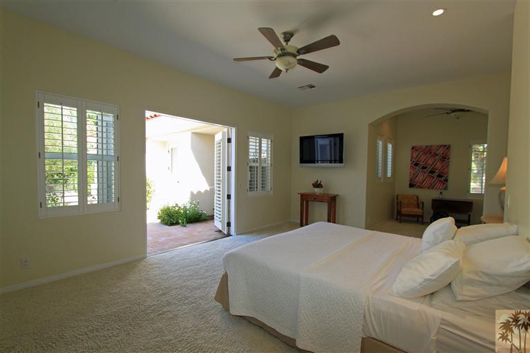 286 Loch Lomond Road Rancho Mirage, CA 92270 - Photo 16 of 24 a large bedroom with a large bed and a chandelier