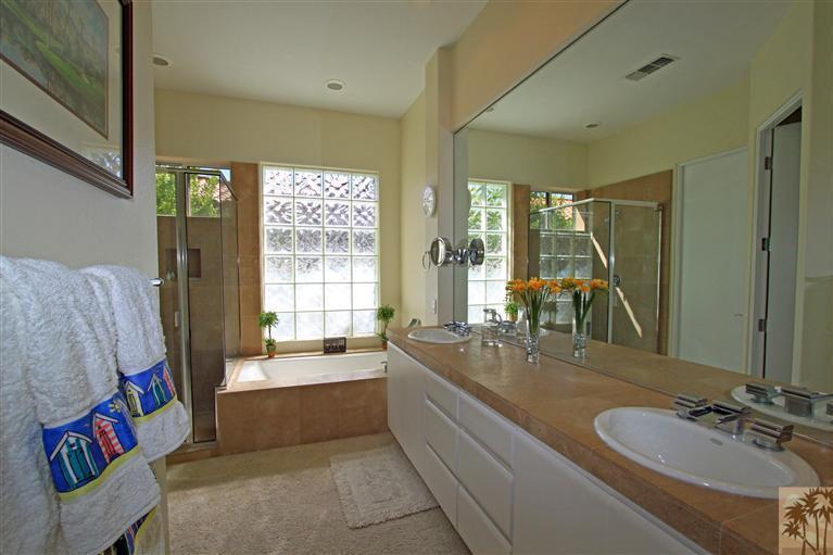 286 Loch Lomond Road Rancho Mirage, CA 92270 - Photo 19 of 24 a bathroom with double vanity sinks a large mirror and a bath tub