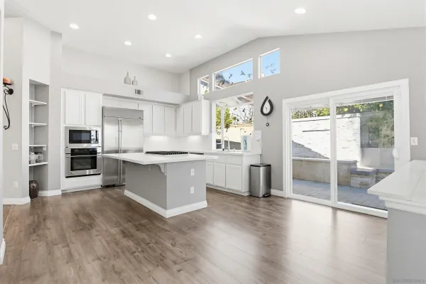 a large kitchen with stainless steel appliances granite countertop a lot of counter space and wooden floor