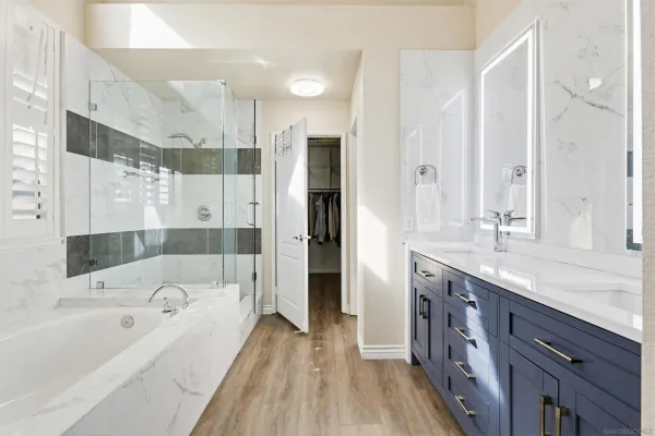 a bathroom with a bathtub shower sink and mirror