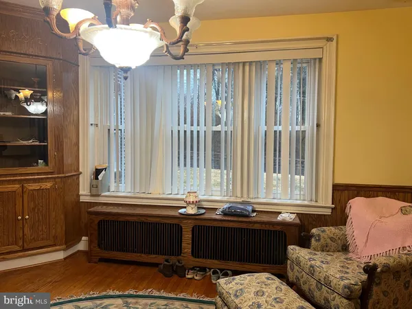 a view of an empty room with a window and kitchen view