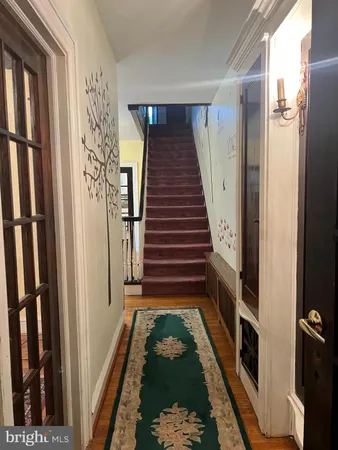 a view of a hallway with wooden floor and a chandelier