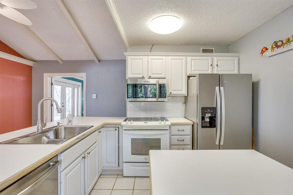 13350 Miller Road Azle, TX 76020 - Photo 16 of 40 a kitchen with white cabinets and stainless steel appliances