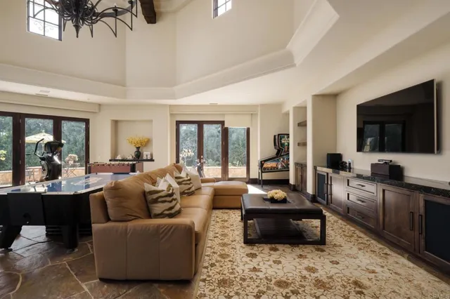 a living room with furniture flat screen tv and large windows