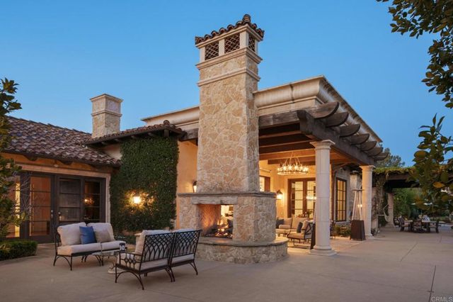 front view of a brick house with a chairs and table in a patio