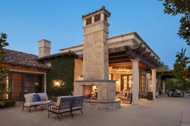 front view of a brick house with a chairs and table in a patio