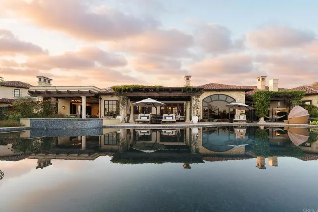 an aerial view of a house with swimming pool and outdoor seating