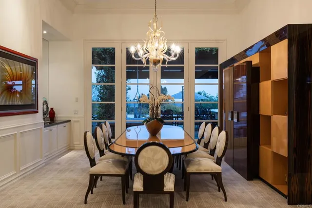 a dining room with furniture a chandelier and window
