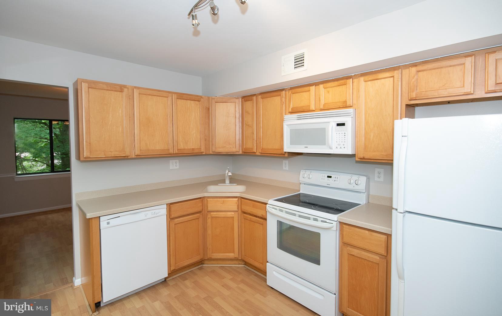 11727 Ledura Court, Unit 201 Reston, VA 20191 - Photo 13 of 29 a kitchen with a white cabinets and white appliances