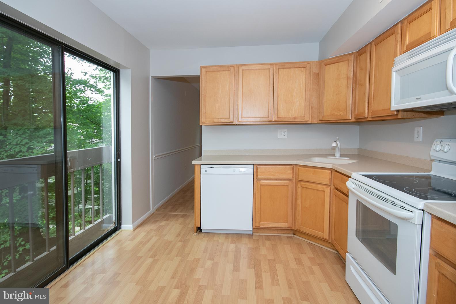 11727 Ledura Court, Unit 201 Reston, VA 20191 - Photo 14 of 29 a kitchen with granite countertop a stove a sink and a white cabinets