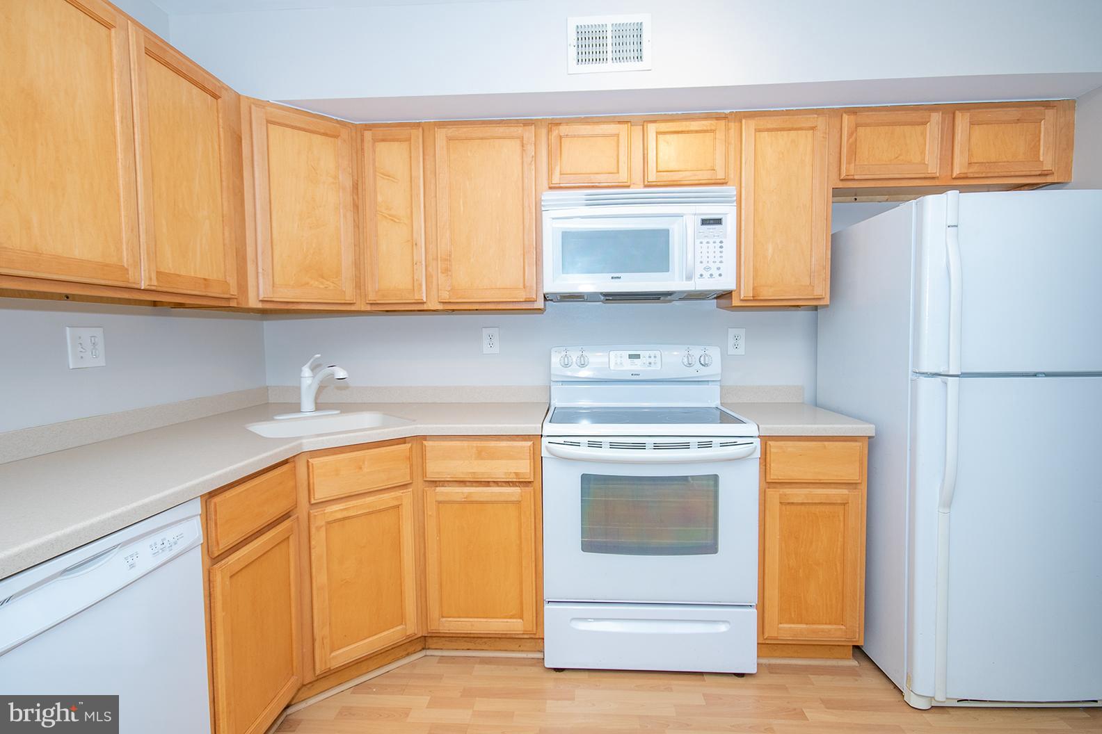 11727 Ledura Court, Unit 201 Reston, VA 20191 - Photo 15 of 29 a kitchen with stainless steel appliances granite countertop a stove a sink and a refrigerator with cabinets