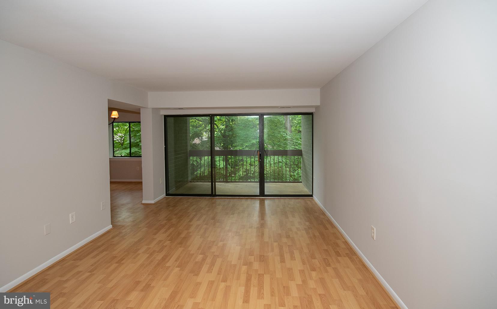 11727 Ledura Court, Unit 201 Reston, VA 20191 - Photo 6 of 29 a view of an empty room with wooden floor and a window