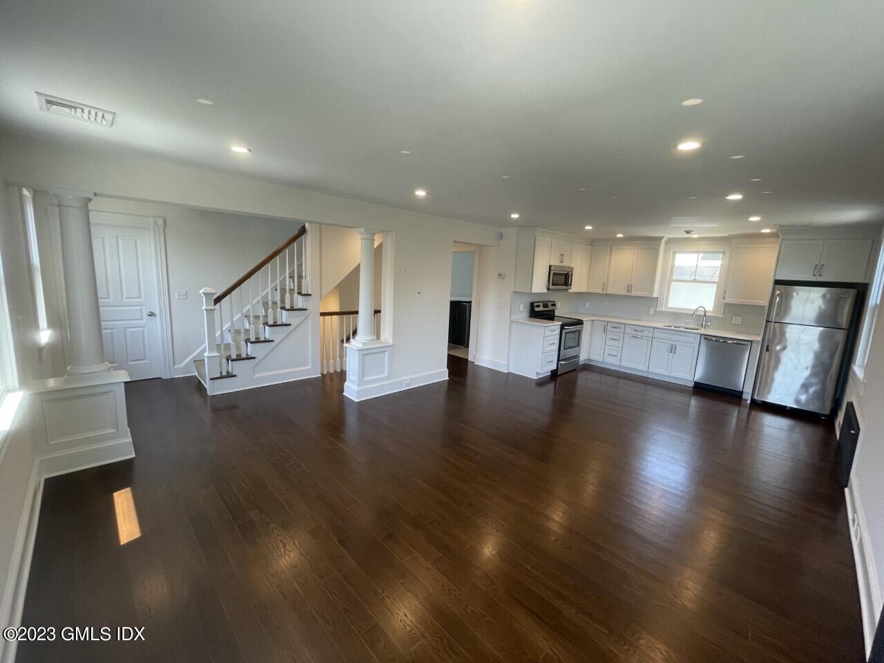 37 Orchard Street, Unit B Cos Cob, CT 06807 - Photo 4 of 15 a view of an empty room with wooden floor and a kitchen