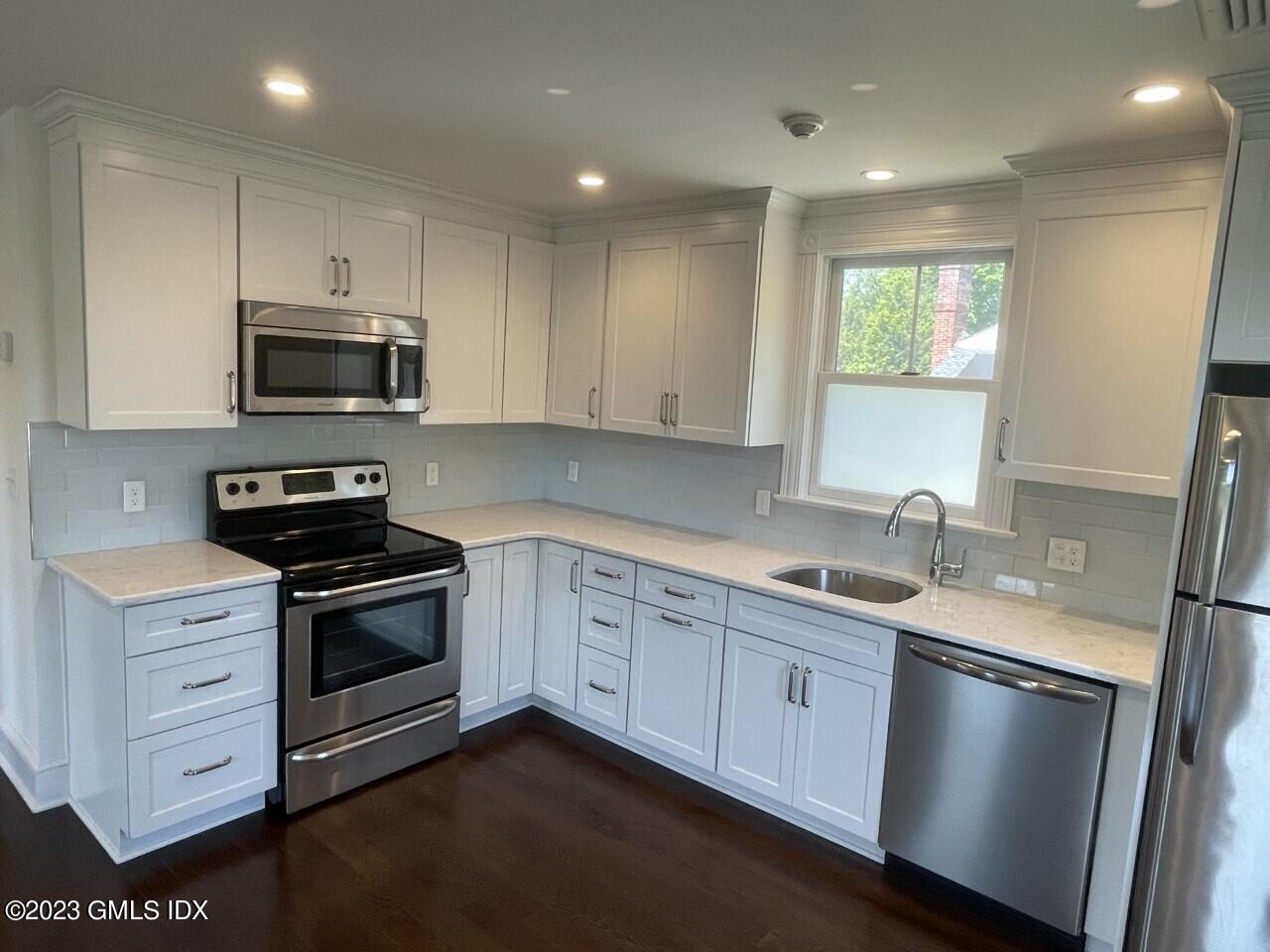 37 Orchard Street, Unit B Cos Cob, CT 06807 - Photo 6 of 15 a kitchen with stainless steel appliances granite countertop a stove a sink and a microwave